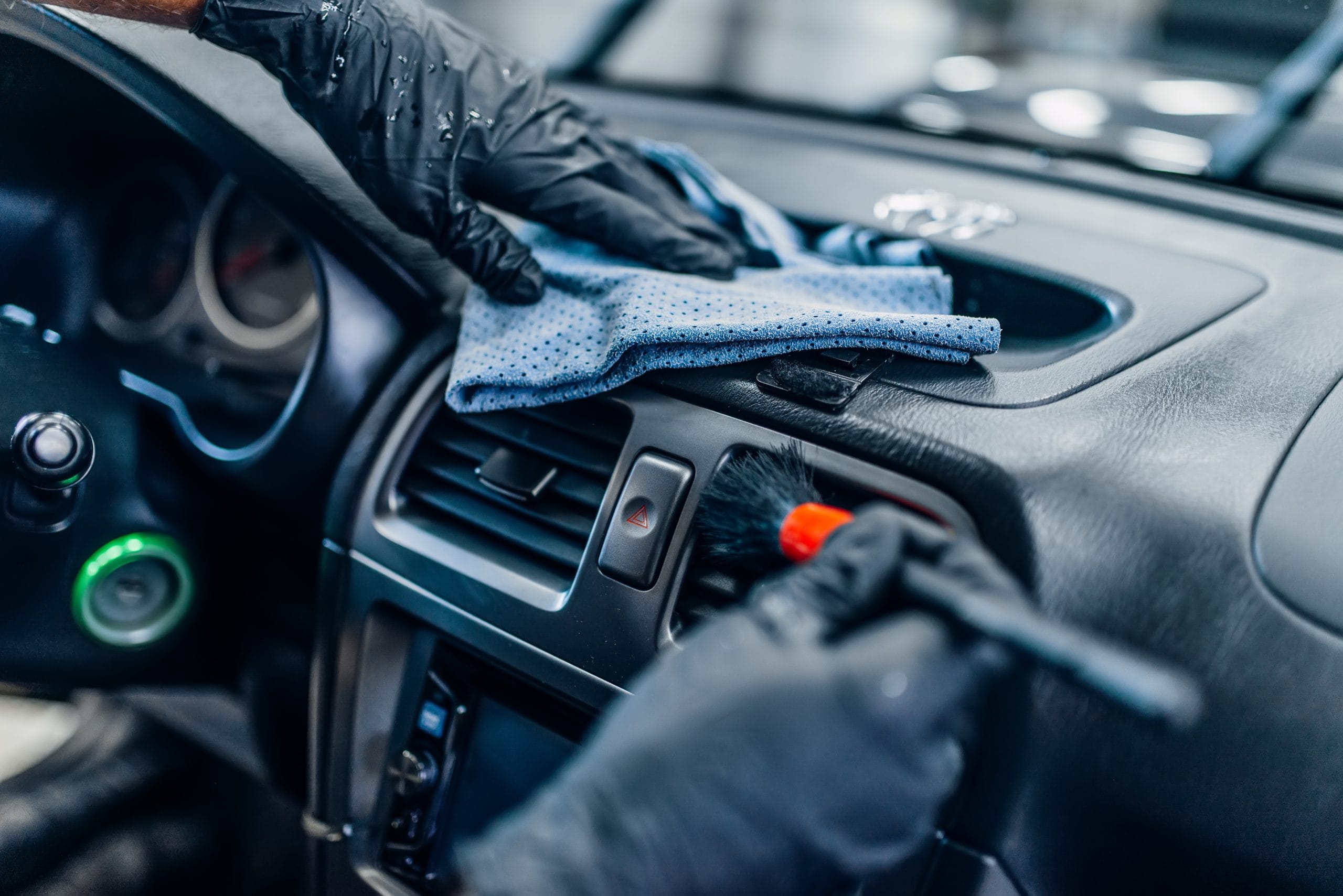 Close-up of hands cleaning car dashboard vents during interior car detailing in Northwest Alabama, now supporting Tuscumbia, Sheffield, Muscle Shoals and Florence!